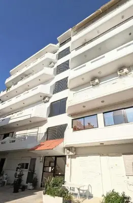 a large white building with chairs in front of it at Pixel Palace in Rhodes Town