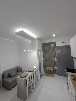 a kitchen and living room with a couch and a table at Pixel Palace in Rhodes Town