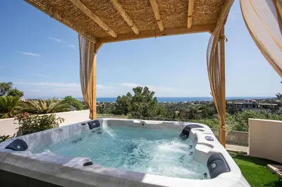a jacuzzi tub on a patio with a view at Zafora Garden in Koskinou