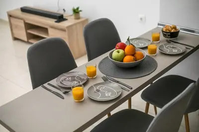 a table with a bowl of fruit and glasses of orange juice at Zafora Garden in Koskinou