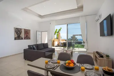 a living room with a table with a bowl of fruit on it at Zafora Garden in Koskinou