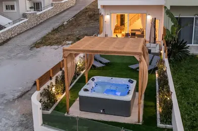 a hot tub on the lawn of a house at Zafora Garden in Koskinou