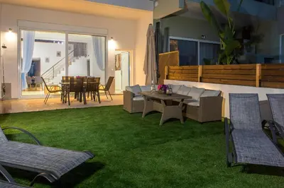 a living room with a couch and a table and chairs at Zafora Garden in Koskinou