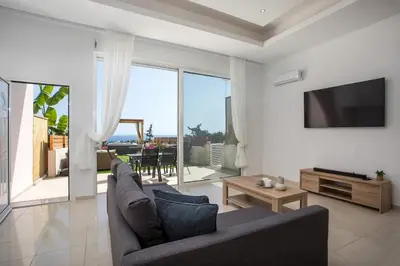 a living room with a couch and a tv at Zafora Garden in Koskinou