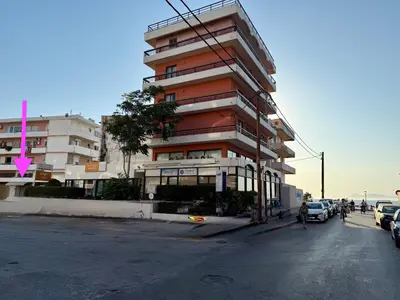 a tall building with cars parked in front of it at Polikseni Apartment Orfanidou in Rhodes Town