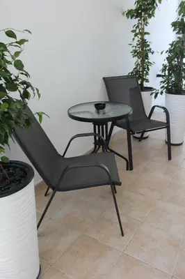 two chairs and a table in a room with plants at Κatholikis Room in Kremasti