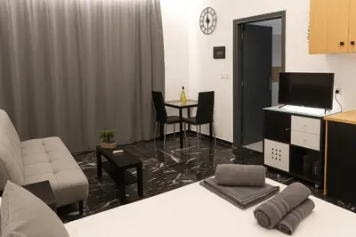 a living room with a couch and a table with chairs at Κatholikis Room in Kremasti