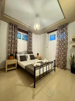 a bedroom with a bed in a room with windows at Casa Guina Solis in Rhodes Town