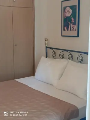 a bed with a white pillow in a bedroom at Beach Sunset Apartment Ialisos in Ialyssos