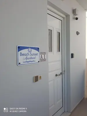 a sign on a wall next to a door at Beach Sunset Apartment Ialisos in Ialyssos