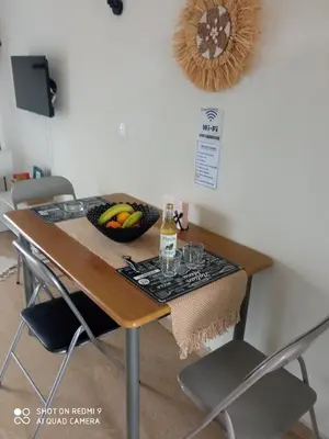 a table with a bowl of fruit and a bottle of wine at Beach Sunset Apartment Ialisos in Ialyssos
