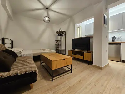 a living room with a couch and a flat screen tv at Elegant Aesthetic Suites in Rhodes Town