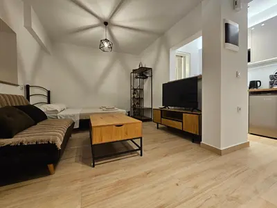 a living room with a couch and a flat screen tv at Elegant Aesthetic Suites in Rhodes Town