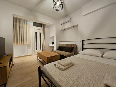 a bedroom with a bed and a couch in it at Elegant Aesthetic Suites in Rhodes Town