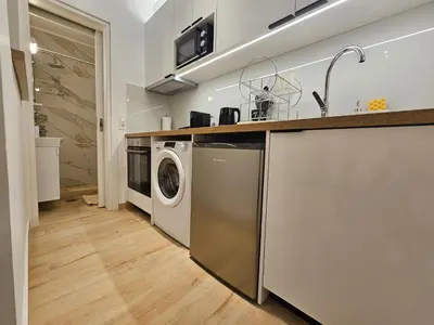 a kitchen with a washing machine and a sink at Elegant Aesthetic Suites in Rhodes Town