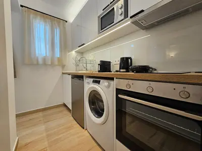 a kitchen with a washing machine and a microwave at Elegant Aesthetic Suites in Rhodes Town