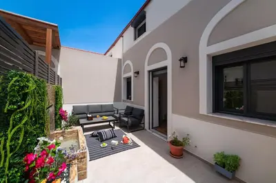 a patio of a house with a couch and chairs at Onour Apartment 1 in Ialyssos