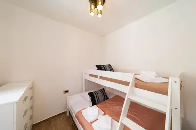 a bedroom with two bunk beds and a ladder at Onour Apartment 1 in Ialyssos