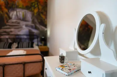 a bedroom with a bed and a mirror on a table at Onour Apartment 1 in Ialyssos