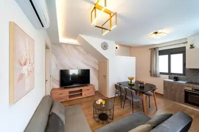 a living room with a couch and a table at Onour Apartment 1 in Ialyssos