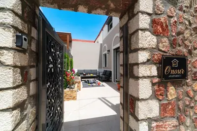 a entrance to a house with a sign on a wall at Onour Apartment 1 in Ialyssos