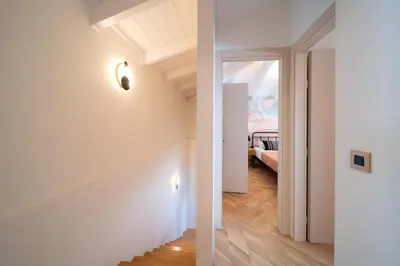 a hallway with white walls and a door to a bedroom at Onour Apartment 1 in Ialyssos