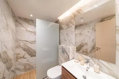 a bathroom with a sink and a toilet and a mirror at Onour Apartment 1 in Ialyssos