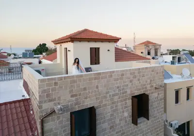 a woman standing on the ledge of a building at Eviona Iris in Rhodes Town