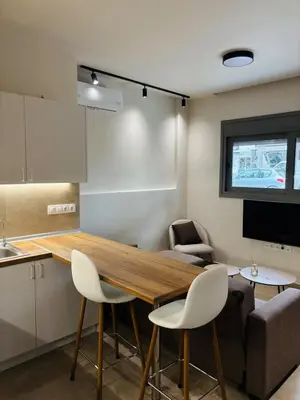 a kitchen and living room with a wooden table and chairs at Sofi's place in Ixia