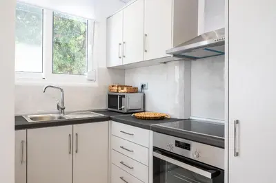 a white kitchen with a sink and a microwave at Asterashouse 2 in Rhodes Town