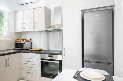 a kitchen with white cabinets and a stainless steel refrigerator at Asterashouse 2 in Rhodes Town