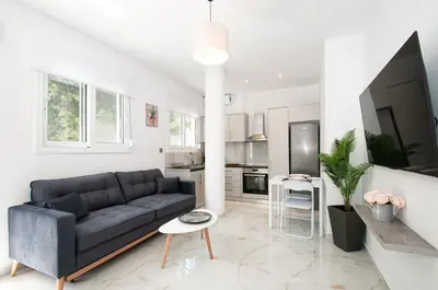 a living room with a black couch and a kitchen at Asterashouse 2 in Rhodes Town