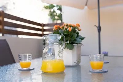 two glasses of orange juice sitting on a table at Eviona Althea in Rhodes Town