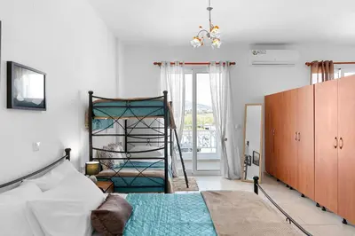 a bedroom with a bed and a ladder in it at Aegean Breeze in Haraki