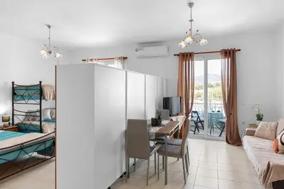 a kitchen and living room with a table and a desk at Aegean Breeze in Haraki