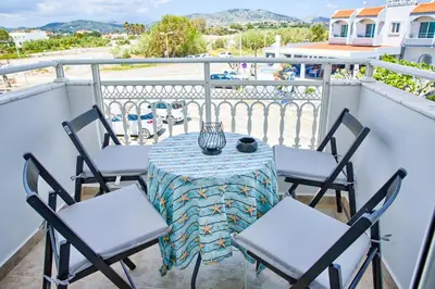 a table and chairs sitting on a balcony at Aegean Breeze in Haraki