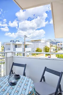 a table and chairs on a balcony with a view at Aegean Breeze in Haraki