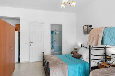 a bedroom with a bed with a blue blanket at Aegean Breeze in Haraki