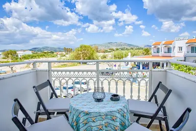 a table and chairs on a balcony with a view at Aegean Breeze in Haraki