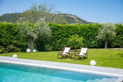two chairs sitting next to a swimming pool at Filerimos Panorama Villa in Pastida
