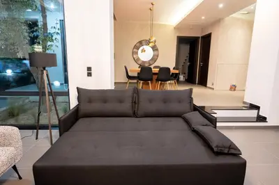 a living room with a couch and a dining room at Filerimos Panorama Villa in Pastida