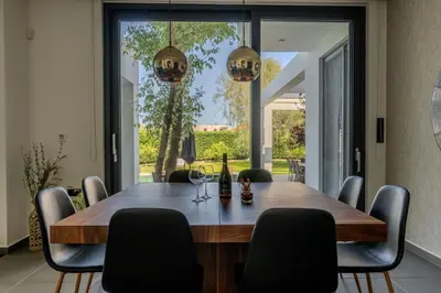 a dining room with a wooden table and chairs at Filerimos Panorama Villa in Pastida