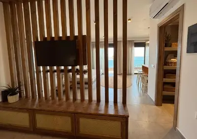 a living room with a flat screen tv on a wall at Aurora Seaside Luxury Suite in Vrachonisída touArchangélou