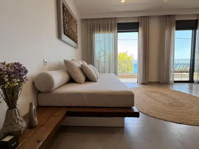 a bed with pillows on it in a living room at Aurora Seaside Luxury Suite in Vrachonisída touArchangélou