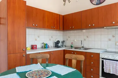 a kitchen with wooden cabinets and a table with a plate at Villa Dimosthenis in Symi