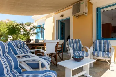 a patio with blue and white chairs and a table at Villa Dimosthenis in Symi