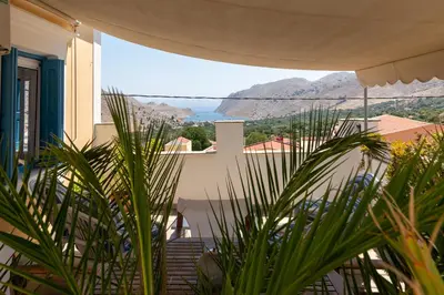a view of a house with mountains in the background at Villa Dimosthenis in Symi