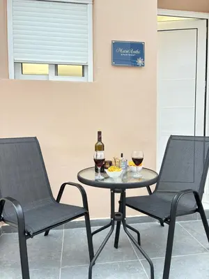two chairs and a table with two glasses of wine at MariAnthi Apartment in Kremasti