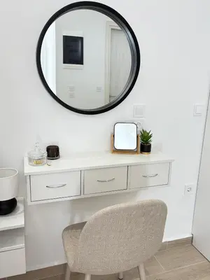 a mirror above a white dressing table with a chair at MariAnthi Apartment in Kremasti