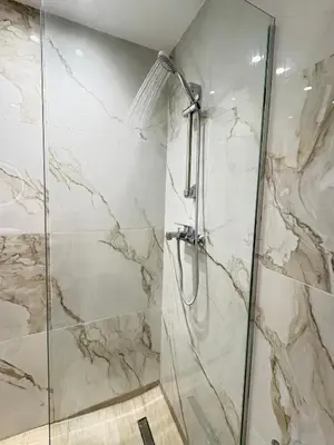 a bathroom with a shower with marble walls at MariAnthi Apartment in Kremasti